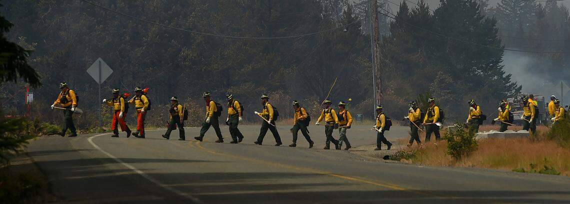 Fire crews cross E. McEwan Prairie Rd. on Wed. July 5, 2023 near Shelton, Wa. as they continue to battle the large brush fire which erupted on July 4. All Level 3 evacuation orders in Mason County prompted by the McEwan Fire were downgraded to Level 2 at noon Wednesday, according to the Mason County Sheriff’s Department. The Level 3 orders put in place on Tuesday required people to leave their homes immediately. Under Level 2, residents of the 200 or so affected homes were encouraged to remain away from the area, but they could return if they could remain prepared to evacuate at a moment’s notice.