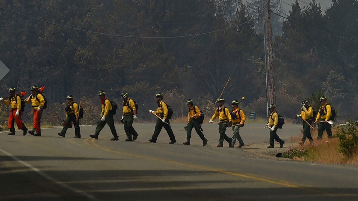 Fire crews cross East McEwan Prairie Road on Wednesday, July 5, near Shelton as they battle the large brush fire that began on July 4.