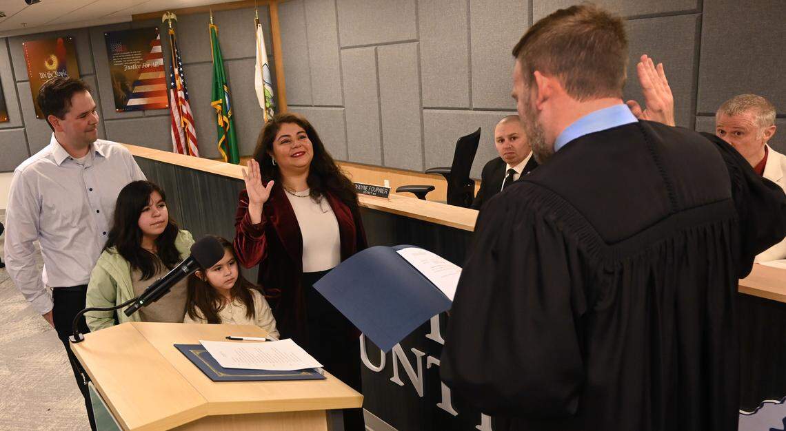 Joined at the podium by her husband Tom and daughters Bella, 11, and Camila.5, newly re-elected Thurston County Commissioner Carolina Mejia is sworn in by Superior Court Judge Chris Lanese the Dec 17, 2024 ceremony at the Atrium building in Olympia which houses county services. ...