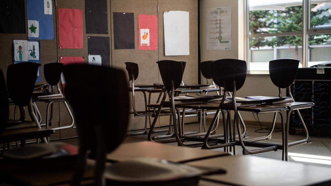 Chairs are seen stacked on desks in Tacoma, Wash., on Monday, March 16, 2020. 