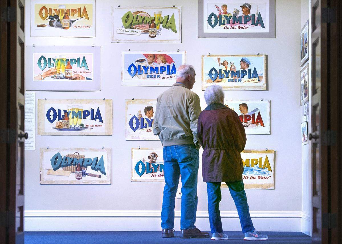 Retired Olympia Brewery worker Joe Lohrengel of Black Lake and his wife, Doris Lohrengel, take in the nostalgia during the opening of the “It’s the Art” Olympia Beer Advertising Art Show in 2017.