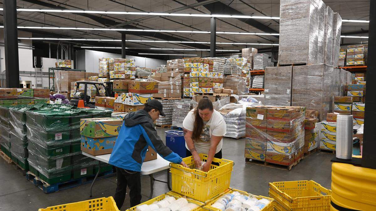 Volunteers Jullysa Daylynn and Matty Graffagnino pack paper products in the Thurston County Food Bank’s 30,000-square-foot warehouse in Olympia earlier this year.