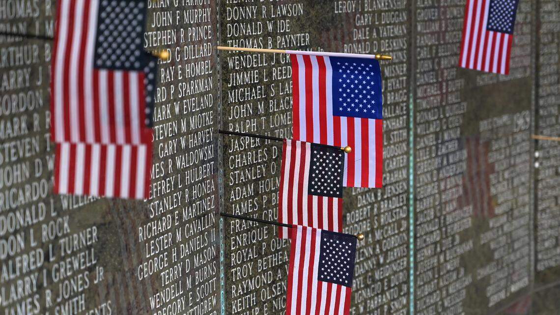 Flags hang from the wall of names of those who served in Vietnam during the Memorial Day ceremony at the Washington State Vietnam Veterans Memorial on the east Capitol Campus on Monday, May 29, 2023.