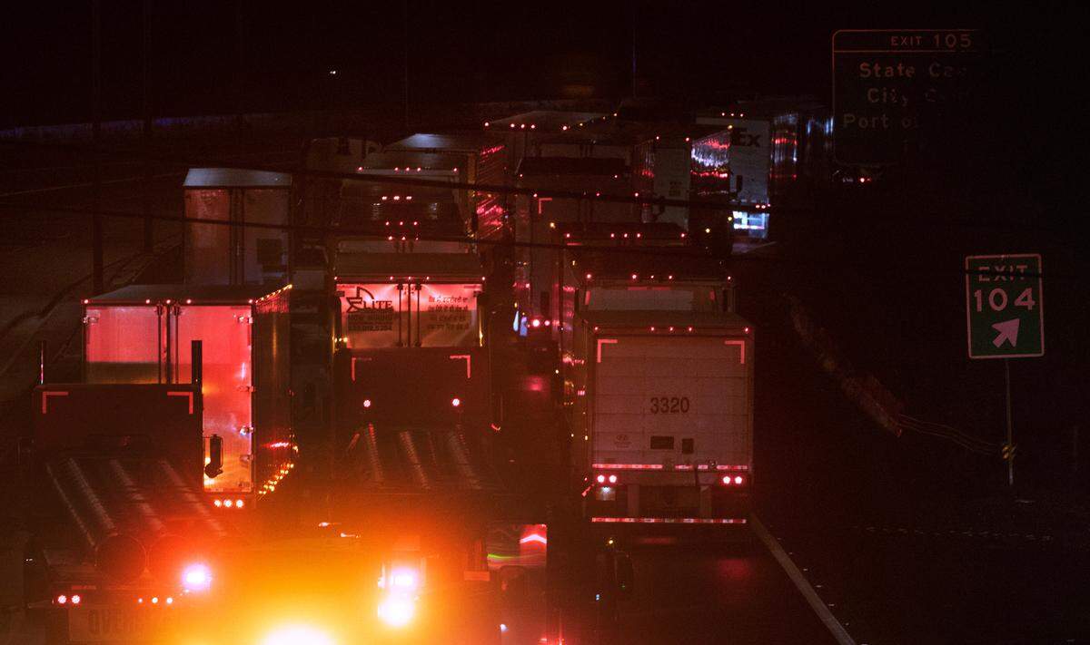 Trucks are stuck on northbound Interstate 5 as crews worked to clear an overturned tractor-trailer on southbound freeway at the Highway 101 interchange in Tumwater, Washington, late on Monday, Oct. 16, 2023.
