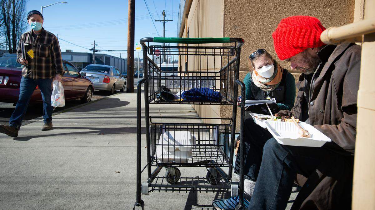 Volunteer Eliza Ramsey of Seattle talks with Dana Smith during the Point in Time homeless census outside the Salvation Army shelter in downtown Olympia in 2022.