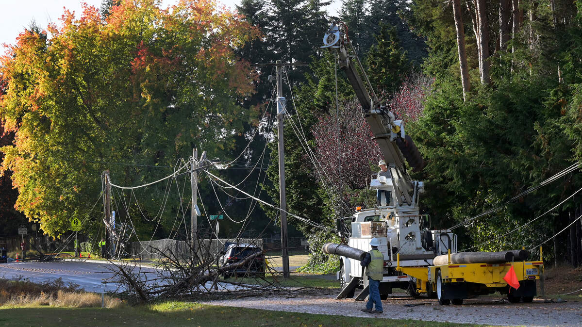 Puget Sound Energy repair crews work to replace several downed power poles and lines along Rainier Road Southeast near Horizons Elementary School in Lacey on Saturday, Nov. 5, 2022 after a Friday night storm turned the lights out for thousands in the area. Early Saturday morning, Puget Sound Energy’s outage map showed over 90 outage locations in Thurston County; about 200,000 were estimated without power throughout Western Washington. Some river flooding was reported, but most rivers were receding by mid-day Saturday. Rain was expected to return Saturday night and continue through Monday.