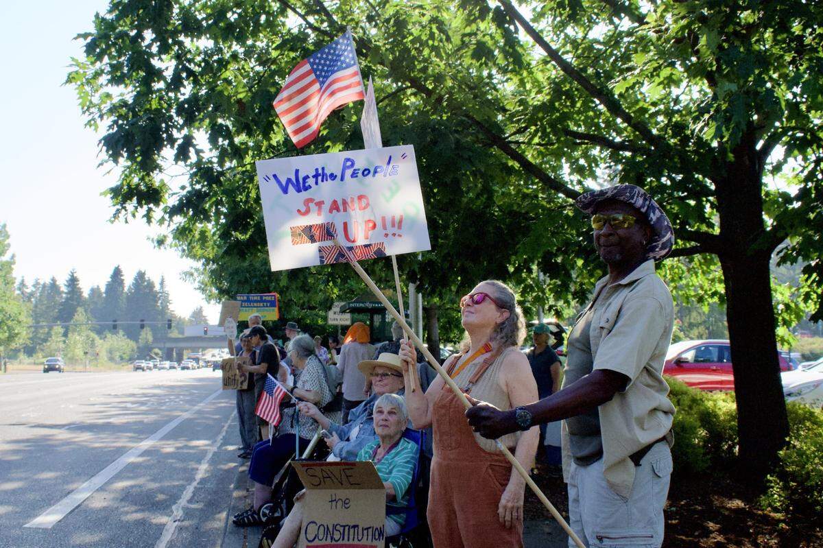 Protesters lined the streets of Martin Way East between the Interstate 5 north ramp and the Martin Way Park and Ride, rallying in honor of the late Democratic congressman and civil rights activist John Lewis.