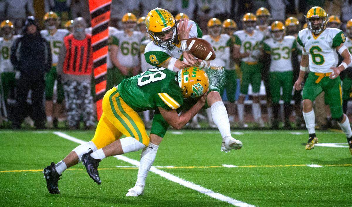 Tumwater defensive back Ryan Orr jars the ball loose from Lynden wide receiver Isaiah Stanley during Saturday night’s 2A football state championship game against the Lynden Lions at Sparks Stadium in Puyallup, Washington, on Dec. 4, 2021. Lynden won the title, 21-7.