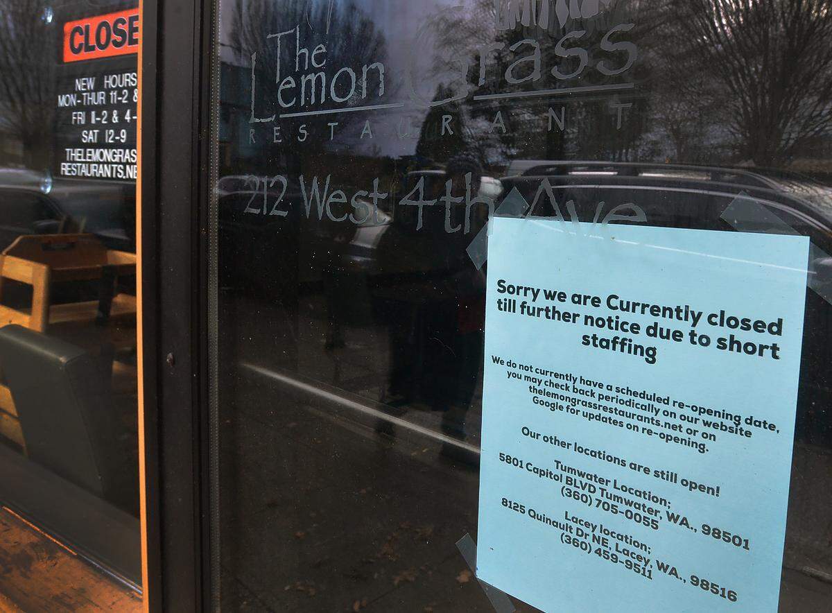 A sign posted on the door of the Lemon Grass restaurant in downtown Olympia on Dec. 22, 2022 announces its temporary closure due to staffing shortages.