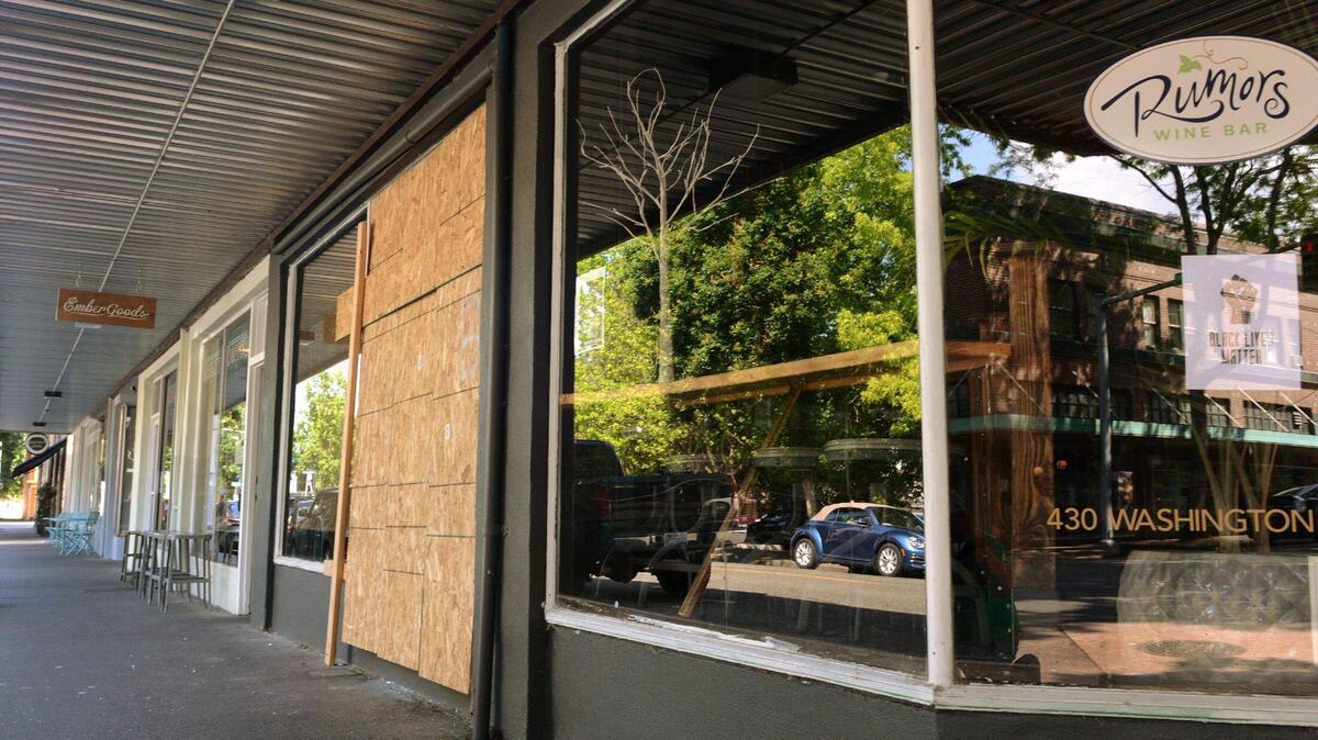 Sheets of plywood cover a window at Rumors Wine Bar in downtown Olympia Sunday July 5, 2020 after vandals struck several downtown businesses on Independence Day. photo taken July 5,2020