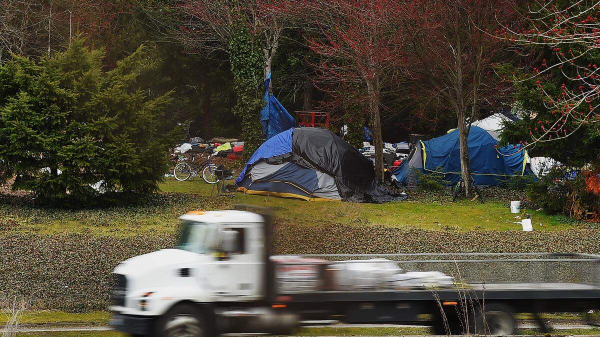 People camp along Interstate 5 next to the Sleater-Kinney Road Northeast overpass on March 28. The number of people counted in Thurston County’s 2023 homeless census increased compared to 2022.