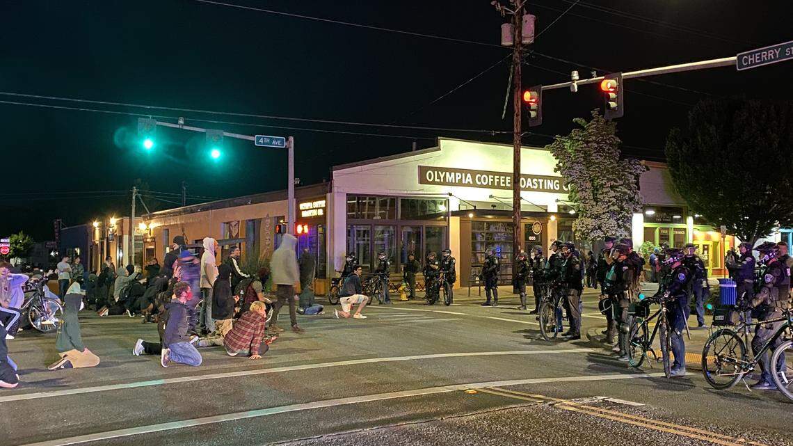 Protesters and Olympia police face off near City Hall about 10 p.m. Sunday. Protesters kneeled with their hands up, chanting and swearing at police.