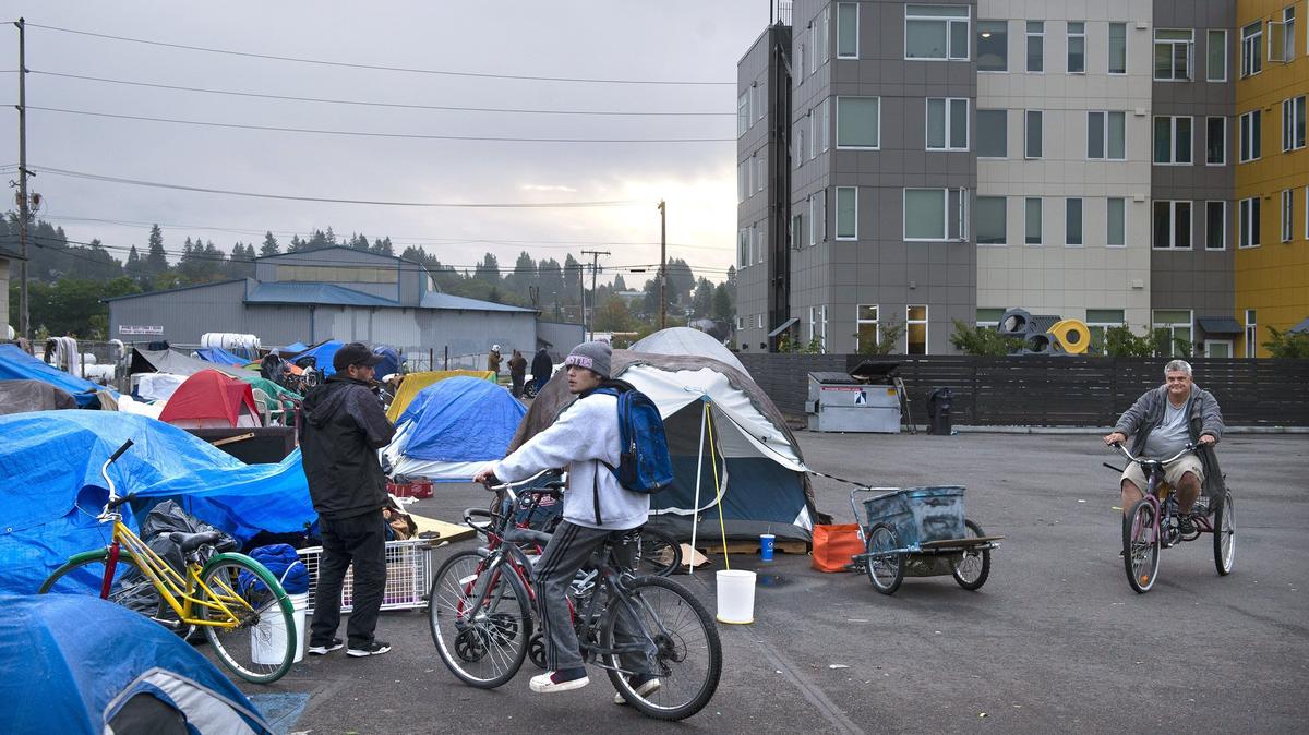 People camp in a city-owned parking lot across from the Puget Sound Estuarium last month. The number of tents has grown in recent weeks, and now Estuarium leaders say they may have to move if things don’t change.