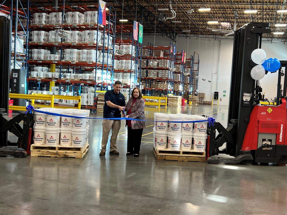 Tumwater Mayor Debbie Sullivan participates in a ribbon-cutting ceremony for the new Benjamin Moore paint distribution center on Dec. 5.