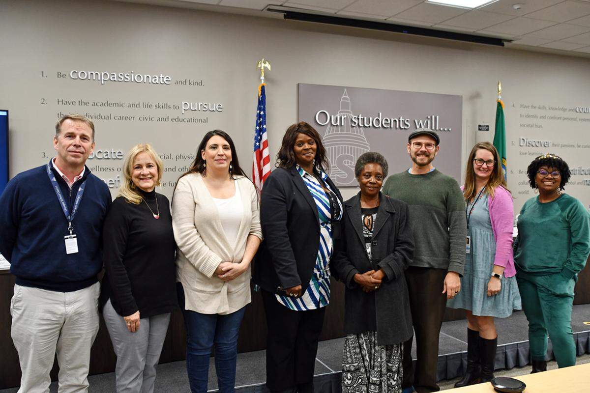 Talauna Reed, fourth person from the left, stands with a family member and the rest of the Olympia School District board of directors and a student representative on Oct. 27. The board appointed Reed to the District 2 position.
