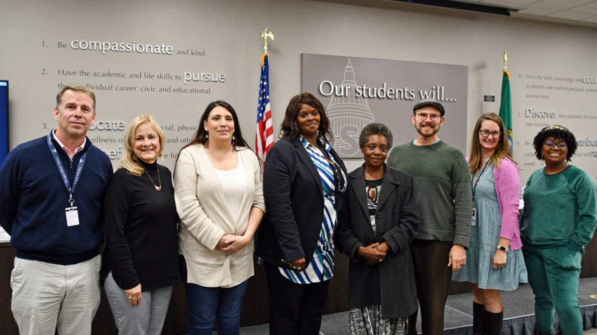 Talauna Reed, fourth person from the left, stands with a family member and the rest of the Olympia School District board of directors and a student representative on Oct. 27. The board appointed Reed to the District 2 position.