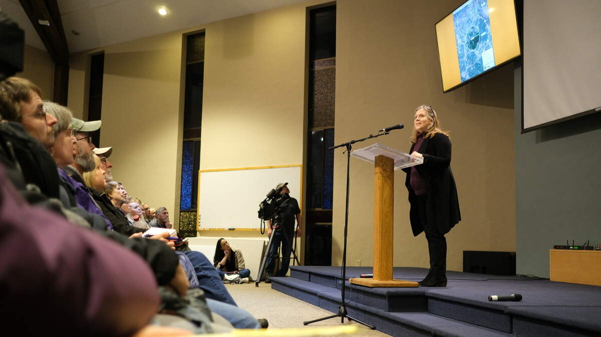 Dawn Sonntag, chief organizer of Stop the Thurston Airport, stands before a packed meeting room at Grace Community Covenant Church on Wiggins Road on Monday, Nov. 16. Her group set up the meeting to raise awareness about the state considering a central Thurston County site for a new airport as Sea-Tac reaches capacity.