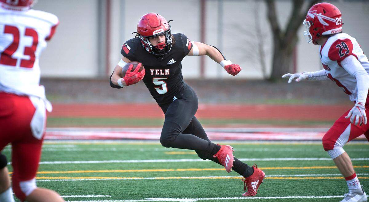 Yelm wide receiver Kyler Ronquillo tries to elude Marysville-Pilchuck defensive back Carson Kuchera during Saturday afternoon’s 3A football state quarterfinal game at Yelm High School in Yelm, Washington, on Nov. 20, 2021. Marysville-Pilchuck won the game, 39-21.