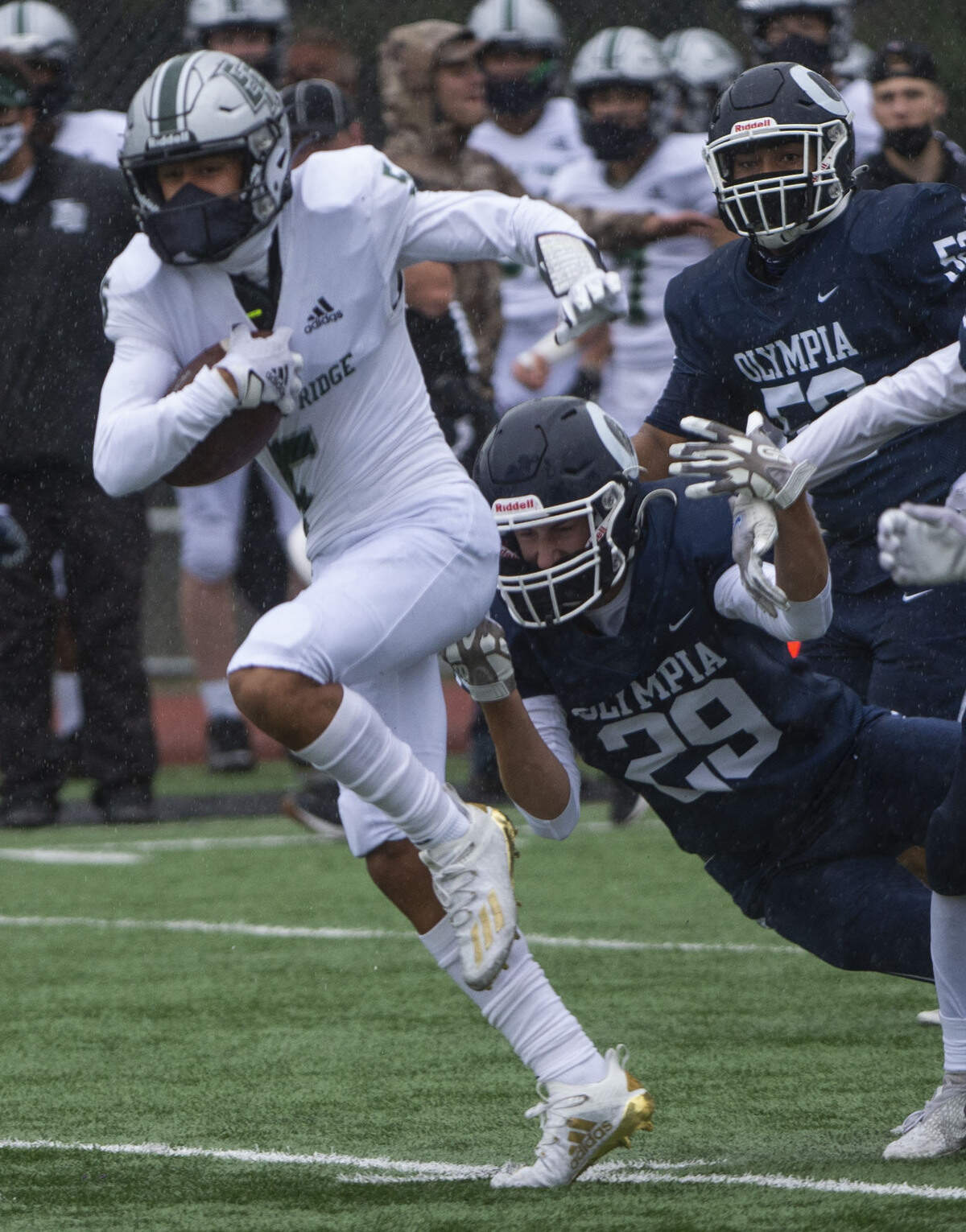 Jaguars wide receiver Tony Harste high steps out of the grasp of an Olympia defender. The Emerald Ridge Jaguars hung on to defeat the Olympia Bears, 28-26, at Ingersoll Stadium in Olympia on Saturday, Sept. 18, 2021.