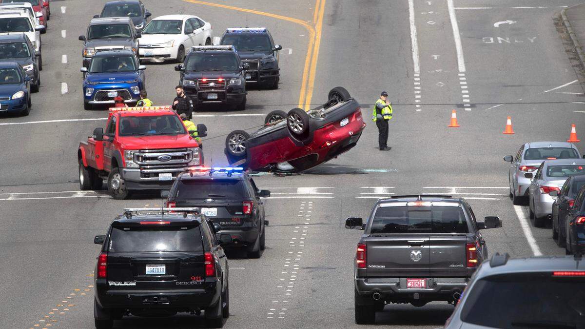 Emergency crews work to right an overturned car on Crosby Boulevard at Mottman Road in Tumwater, Washington, on Saturday, March 25, 2023.
