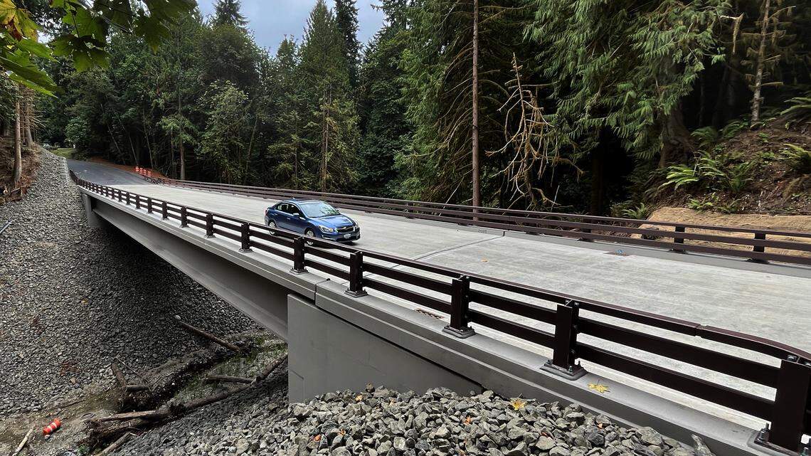 A motorist crosses the new bridge spanning Green Cove Creek on Sep.t 2, 2025 after a year-long closure to that portion of Country Club Road Northwest just north of the Olympia Country and Golf Club on Cooper Point. The project to replace the older aging bridge was designed to enhance fish passage, improve the health of the creek's ecosystem and improve road safety.


