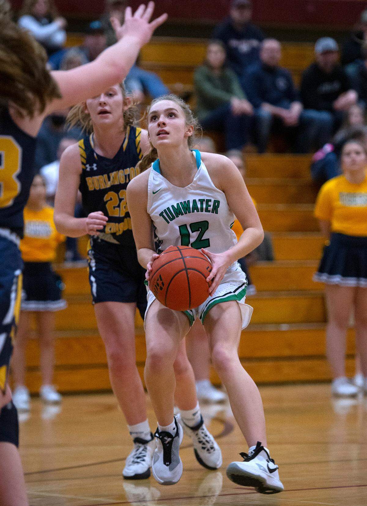 Tumwater’s Aubrey Amendala drives the lane in front of Burlington-Edison defender Analise Slotemaker during Saturday night’s 2A girls basketball state tournament regional-round game at WF West High School in Chehalis, Washington, on Feb. 26, 2022. Burlington-Edison won the game, 52-47.