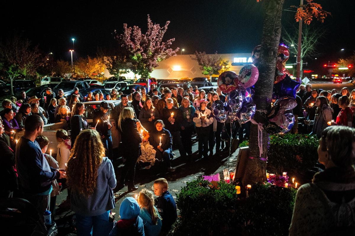 Friends and family gather Friday night for a candlelight vigil in memory of Maryann McCarty, who was killed in the Michael’s parking lot in Lacey by a former domestic partner. Dozens of people showed up to share stories and partake in a moment of silence in McCarty’s memory.