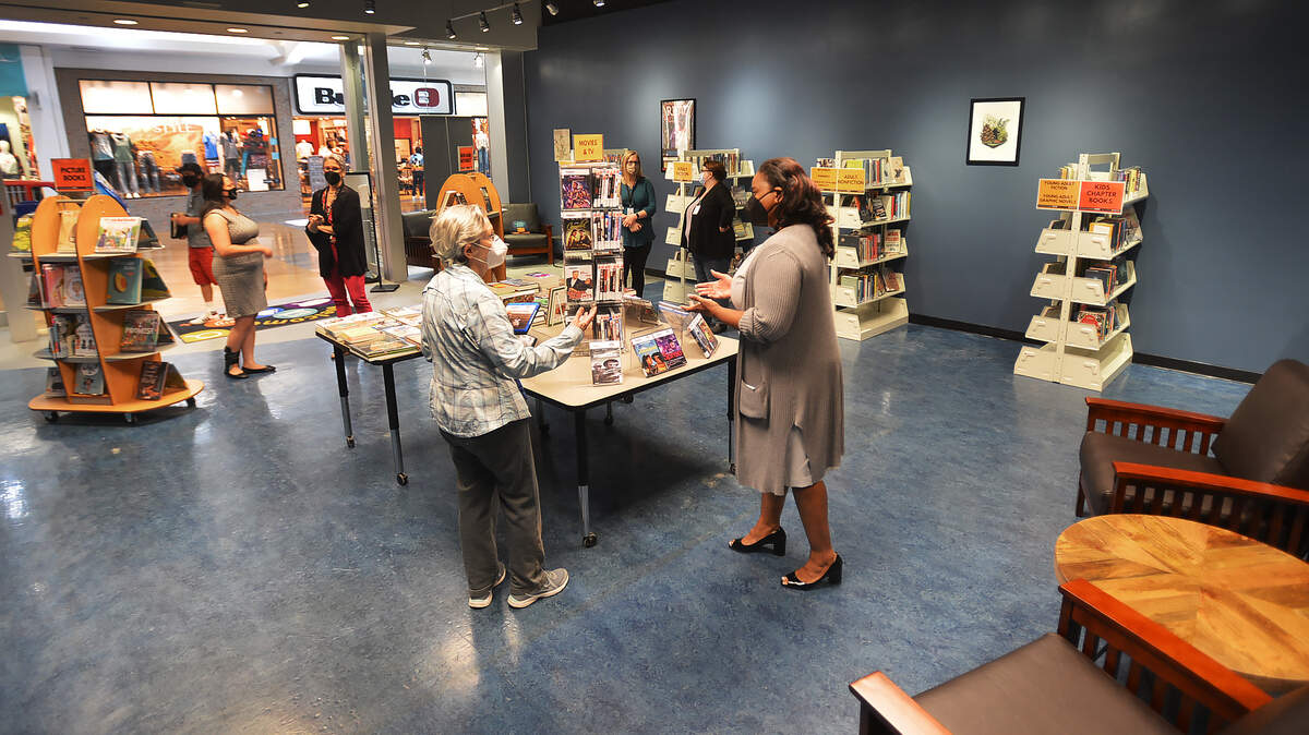 Library manager Stephanie Hope-Cochran (right) chats with one of the first patrons during the June 1 opening for the Timberland Regional Library’s new west Olympia branch at Capital Mall.