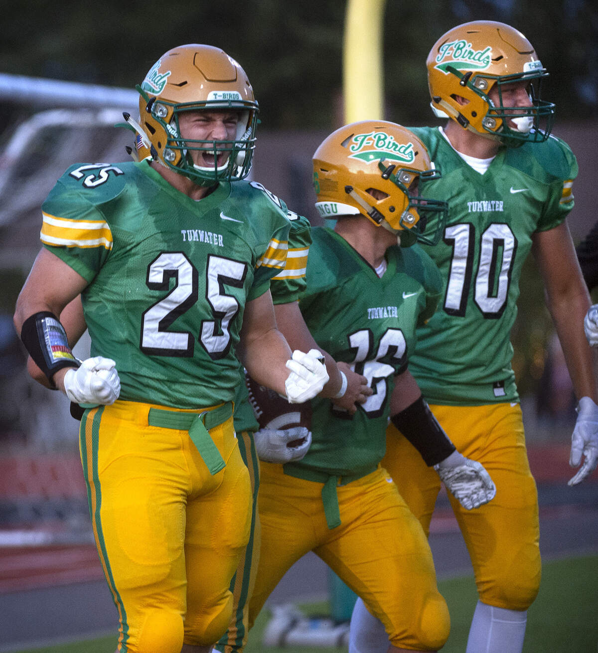 Tumwater’s Tyler Woods (25), Hunter Baker and Ryan Otton (10) celebrate Baker’s touchdown run against Timberline during Friday night’s season-opening football game at Tumwater District Stadium on Sept. 6, 2019.