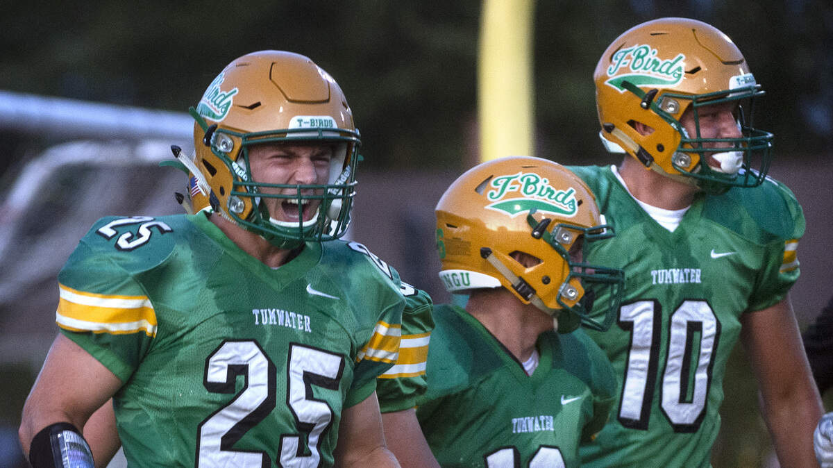 Tumwater’s Tyler Woods (25), Hunter Baker and Ryan Otton (10) celebrate Baker’s touchdown run against Timberline during Friday night’s season-opening football game at Tumwater District Stadium on Sept. 6, 2019.