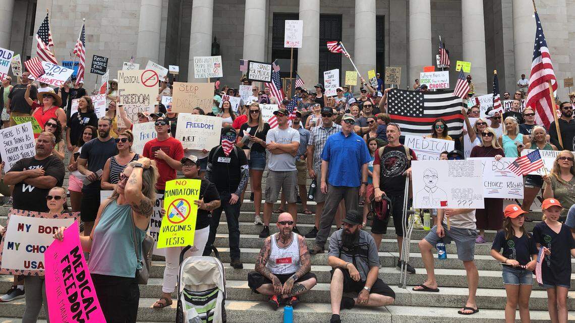 Protesters gather on the steps of the Legislative Building in Olympia Friday to protest Gov. Jay Inslee’s new vaccine mandate for state employees and health care workers.