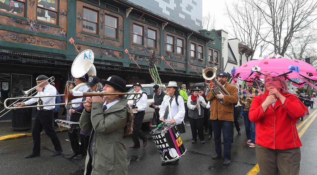 The Artesian Rumble Arkestra, seen here in 2020 parading past Buck’s Fifth Ave. spice shop in honor of its late founder, Anne Buck, will be among the bands participating in Olympia Porch Fest on Monday, Sept. 1.