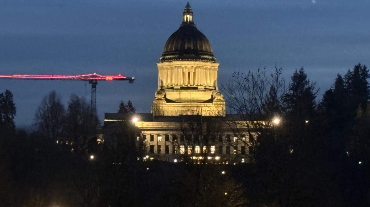The Washington state Capitol building in Olympia is illuminated against a dark sky.