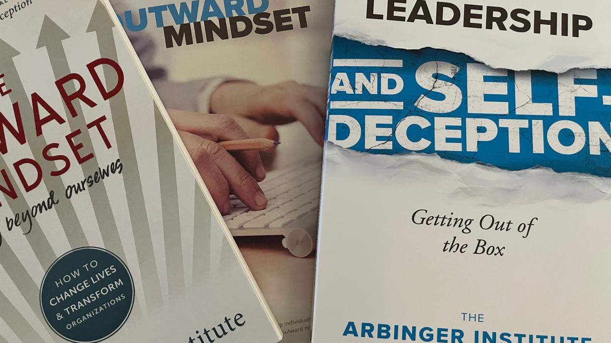 Books from the Arbinger Institute’s “Outward Mindset” training program on June 1, 2023. Some Washington Department of Health employees say that training provided by the Arbinger Institute perpetuate workplace issues.
