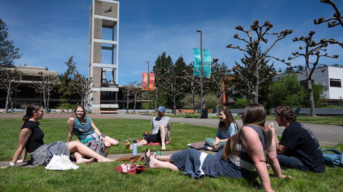 Masters in Teaching students gather in the sunshine for lunch before class at The Evergreen State College in Olympia, Washington, on Friday, May 12, 2023. From left are Elle Personius, Alexis Sanchez, Awren Schwartz, Deanna Aminoff, Francie van Maarth and Shane Donaldson.