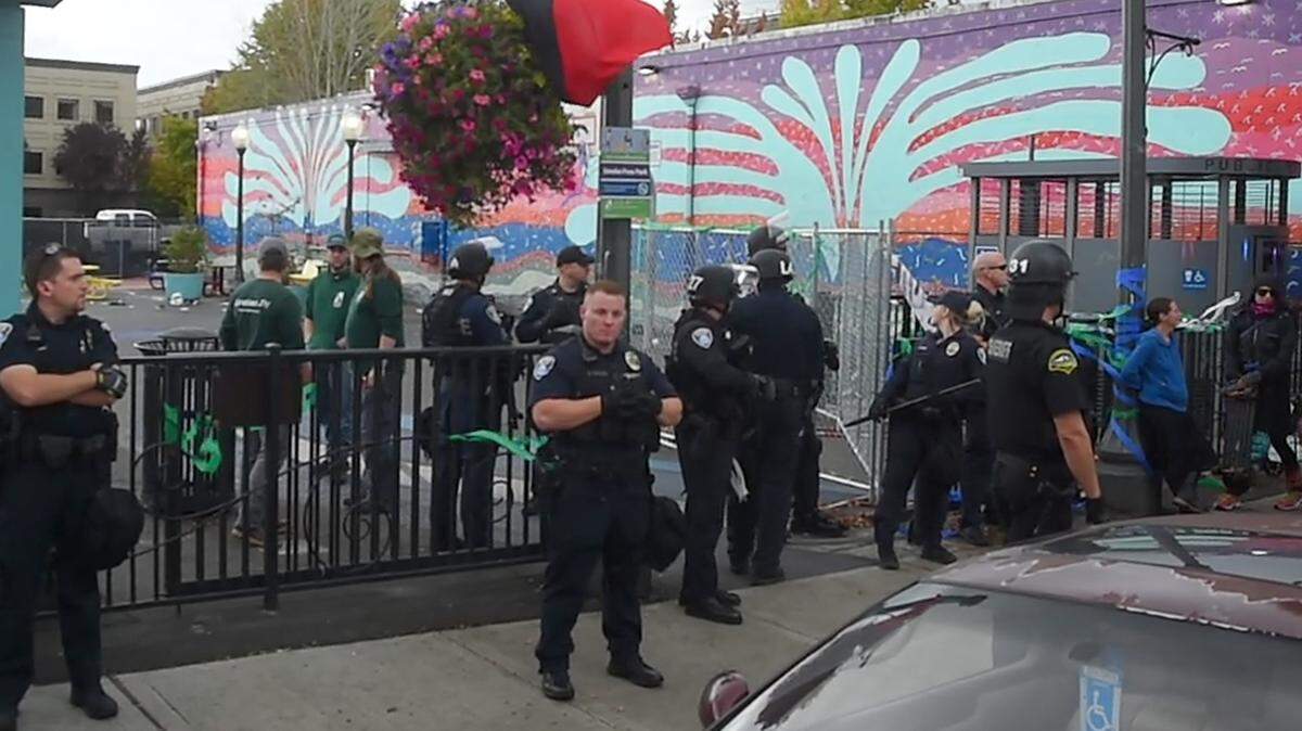 Olympia police respond to a protesters at Artesian Commons Park in September over the park’s closure. Protests and other events can add to overtime costs.