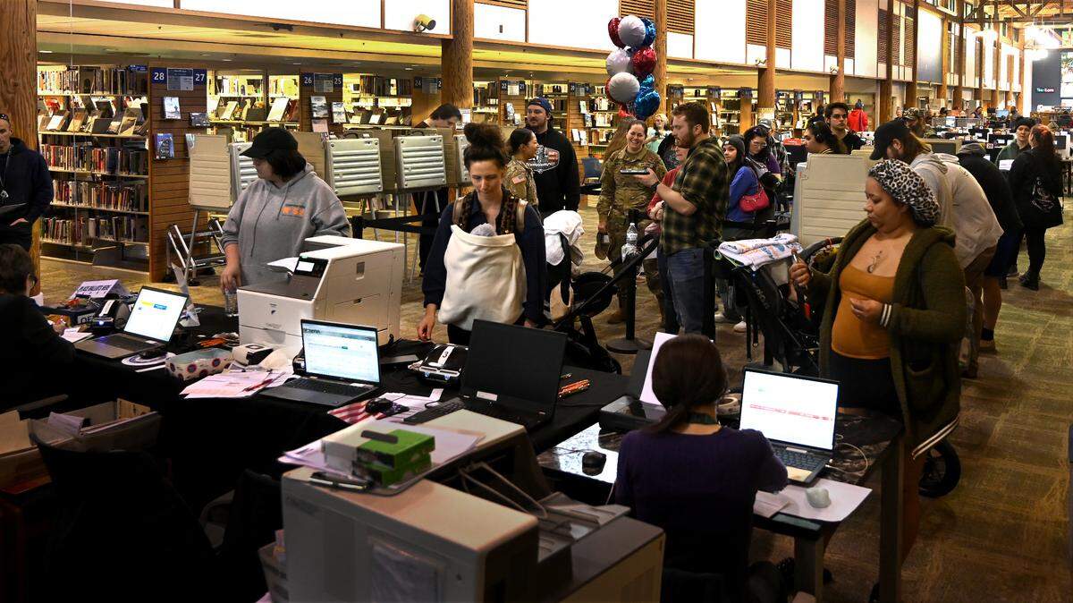 People stand in line at the temporary voting center at the Lacey Timberland Library on election day to get ballots or register to vote.