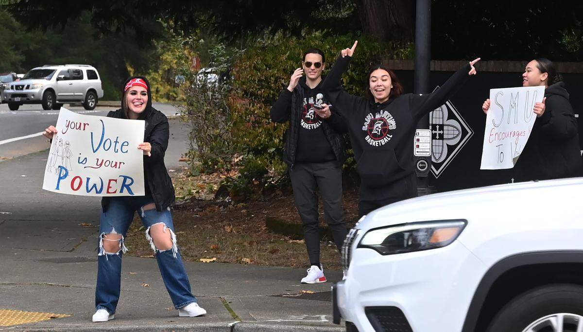 Standing during the lunch hour on Election Day at the intersection of College Street Southeast and Abbey Way, Saint Martin’s University students encourage passing motorists to vote on Tuesday, Nov. 5, 2024.