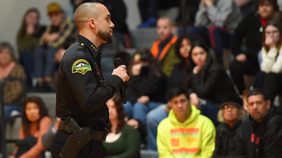 Thurston County Sheriff Derek Sanders addresses a community gathering in the Rainier High School gymnasium during a March 7 evening vigil held in memory of senior Jessie Uch.
