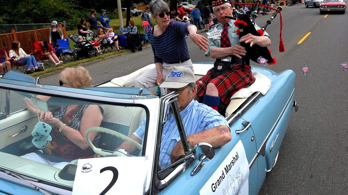 Resplendent in the traditional tartan uniform he wears when playing with the Olympia Highlanders Bagpipe & Drum Corps, renowned Tenino stone carver Keith Phillips fills the air along Sussex Avenuewith sounds of the bagpipes as Grand Marshal for the annual Oregon Trail Days Parade in 2022. He is seated with friend Anne Sweringen, who tossed candy to eager kids along the route.