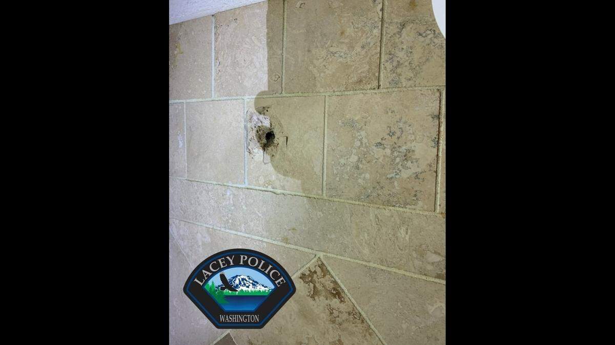 The Lacey Police Department is on the lookout after a Lacey home was shot at, and a bathing child was almost hit. Shown here is damage to the bathroom tiles.