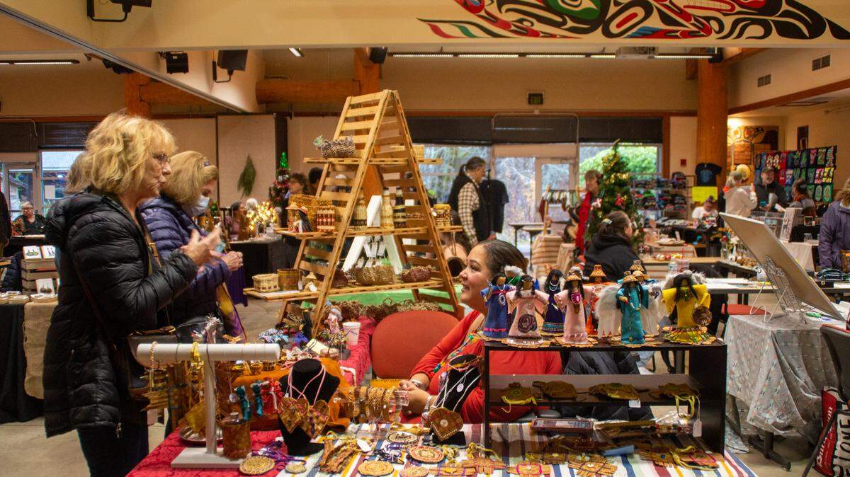 Master weaver Betty Pacheco speaks with customers at The Evergreen State College’s holiday native art fair, where she sold cedar bark Christmas tree ornaments and more on Friday, Dec. 9. Pacheco is the seventh generation of weavers in her family.