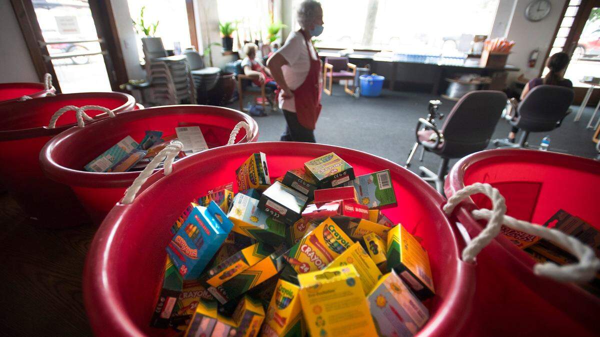 Volunteers gather donated school supplies during the annual fundraiser for the Little Red Schoolhouse project at MIXX-96 radio station in downtown Olympia in 2021.