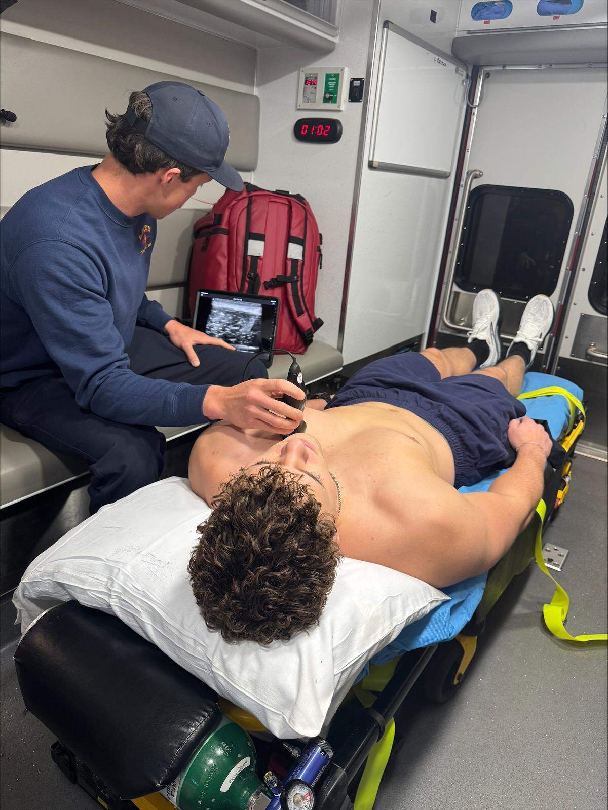 A Thurston County paramedic demonstrates the use of an ultrasound device on a paramedic volunteer inside an ambulance.