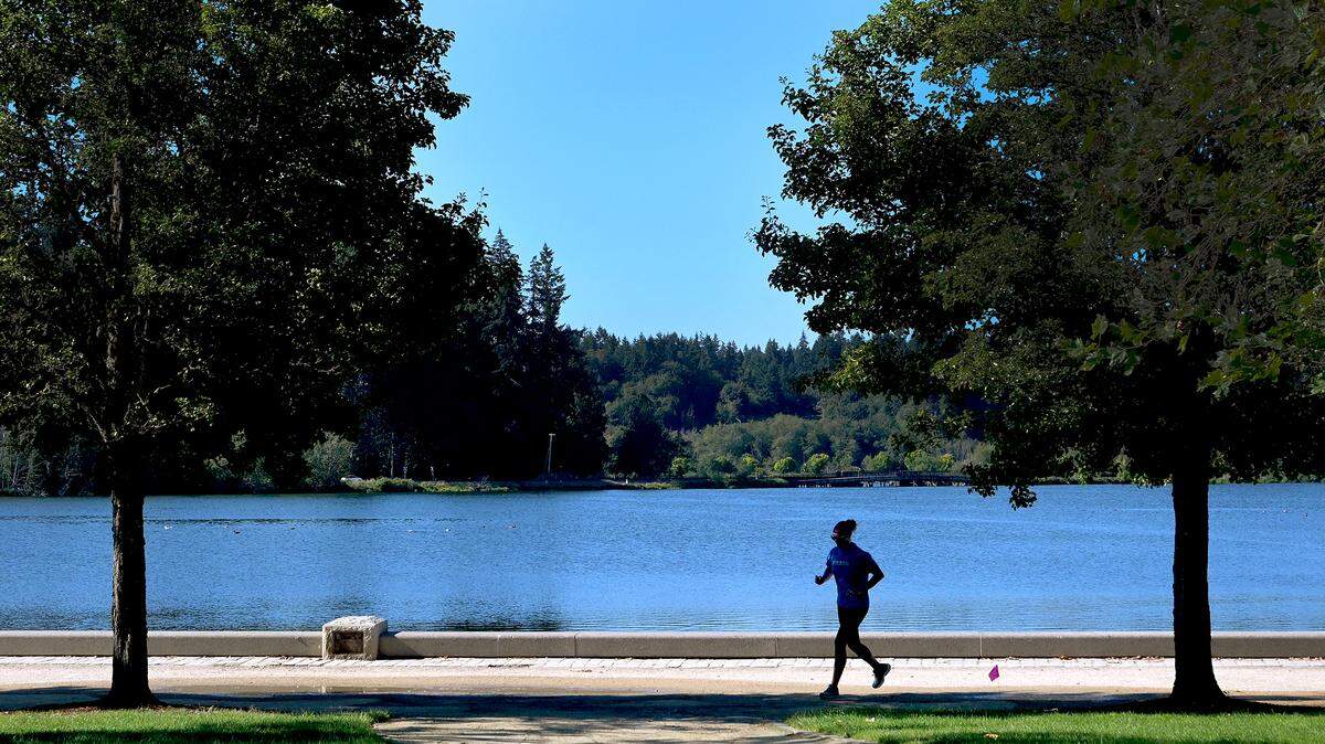 A jogger makes her way around Capitol Lake in Olympia’s Heritage Park.