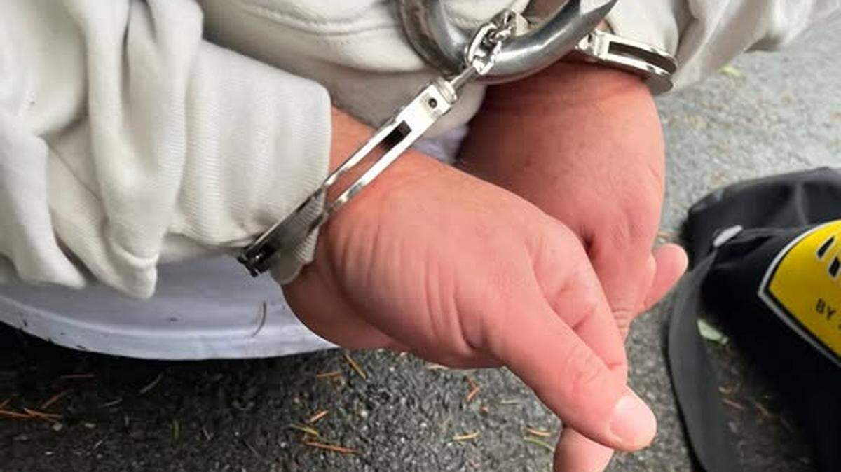 The suspect is shown in custody following his alleged assault of a man outside a Lacey business Thursday afternoon.