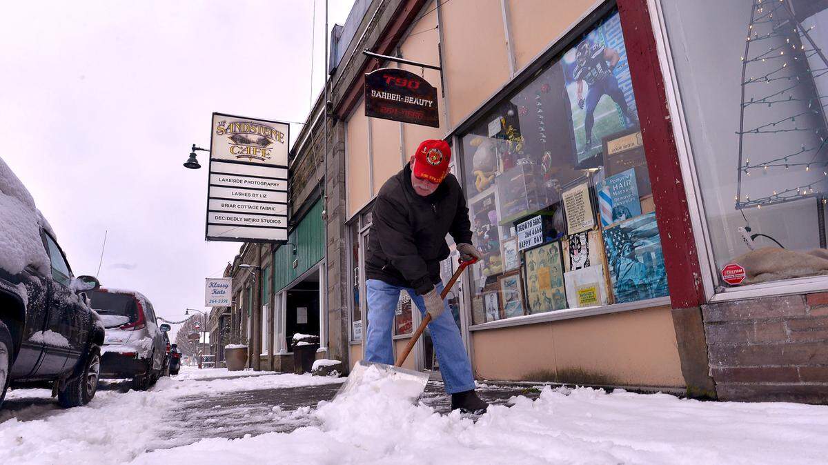 On a very cold Tuesday morning, V.F.W. Post 5878 member Bob Penrod clears the snow in front of the Tenino, Washington post and an adjacent beauty shop as winter weather strengthens it grip in the region.