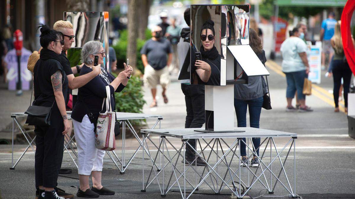 Natalie Barry (from left), of Olympia, her husband Bron Barry and his mother Wanda Sanchez of Phoenix, Arizona, take photos of a mirror art installation on Fifth Avenue during the inaugural LoveOly SummerFest in downtown Olympia in 2021.