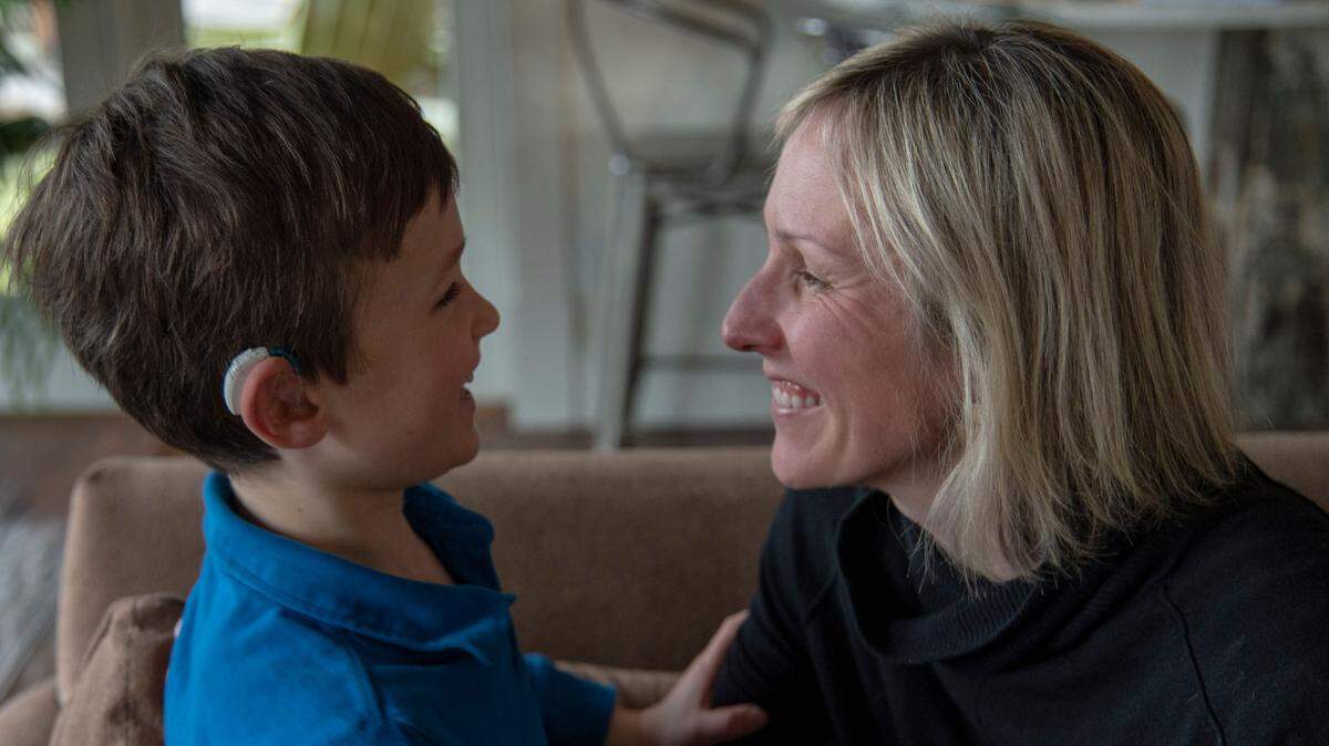 Jill Bujnevicie and her son Hugo hang out on the couch at their home in Normandy Park on Sunday. Jill testified Wednesday for a bill that would provide coverage for hearing aid instruments on behalf of Hugo, who was born with bilateral sensorineural hearing loss.