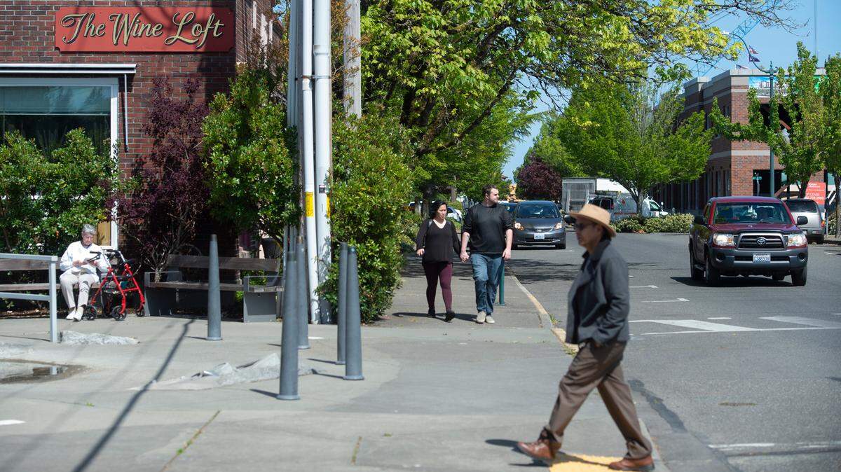 Pedestrians and motorists make their way along the Columbia Street in downtown Olympia on Wednesday, May 1, 2019.